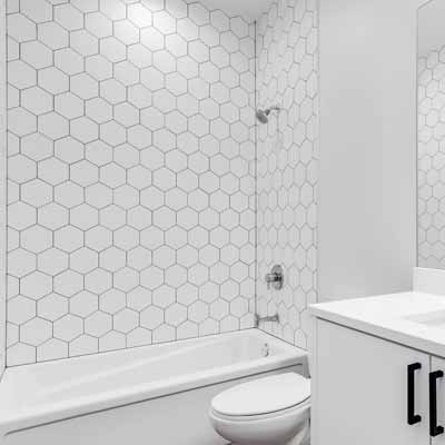 White accent bathroom with hexagon tile shower walls