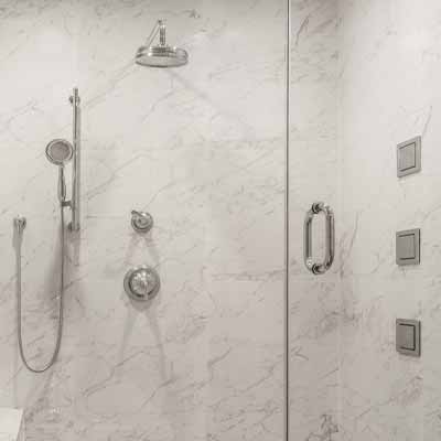 White marble shower with silver accessories.