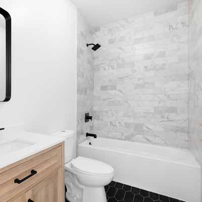 Remodeled shower with gray walls and white tub